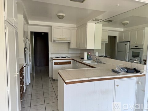 A kitchen with white cabinets and appliances.
