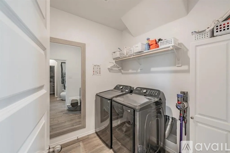 A modern kitchen with a black dishwasher and white cabinetry.