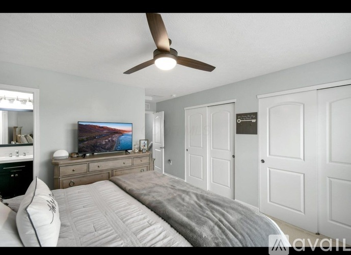 A bedroom with a large bed and a flat screen TV mounted on the wall.