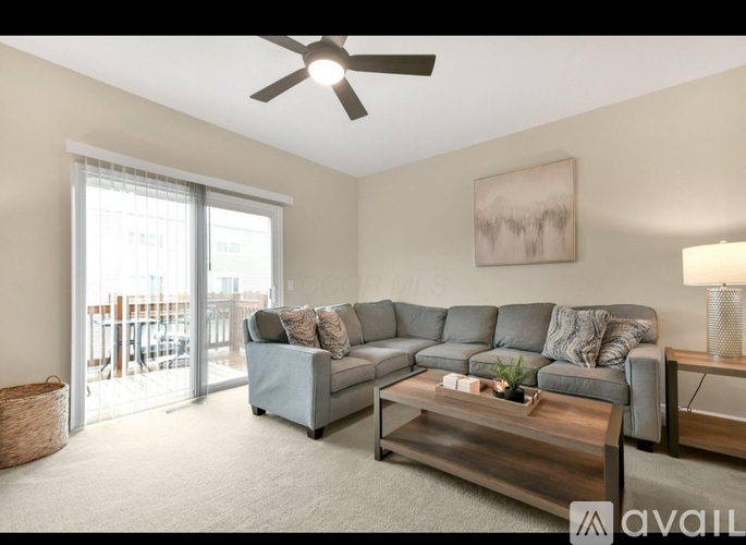A living room with a grey couch and a wooden coffee table.