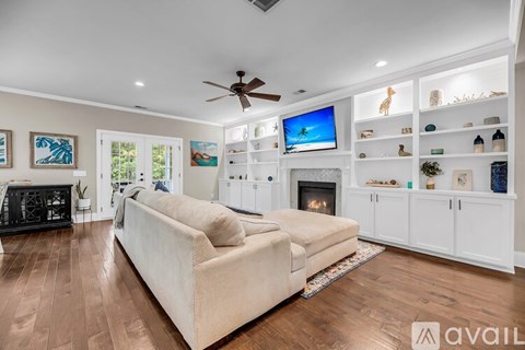 A living room with a beige couch and a fireplace.