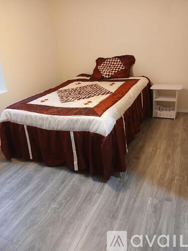 A bed with a brown and white comforter and a pillow with a checkered pattern.