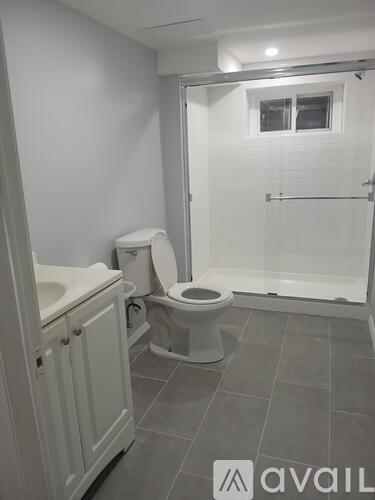 A bathroom with a toilet, sink, and shower.