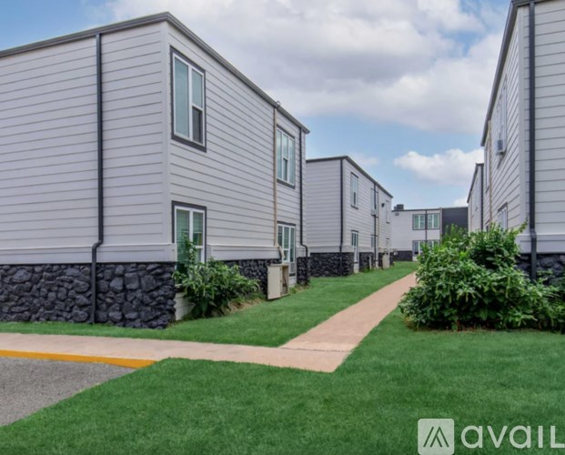 A row of modern houses with a grassy area in front.