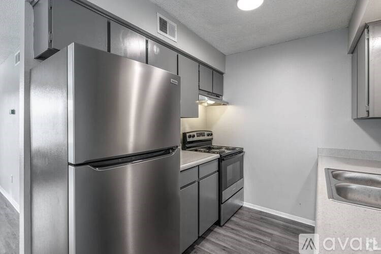 A modern kitchen with a stainless steel refrigerator and dishwasher.