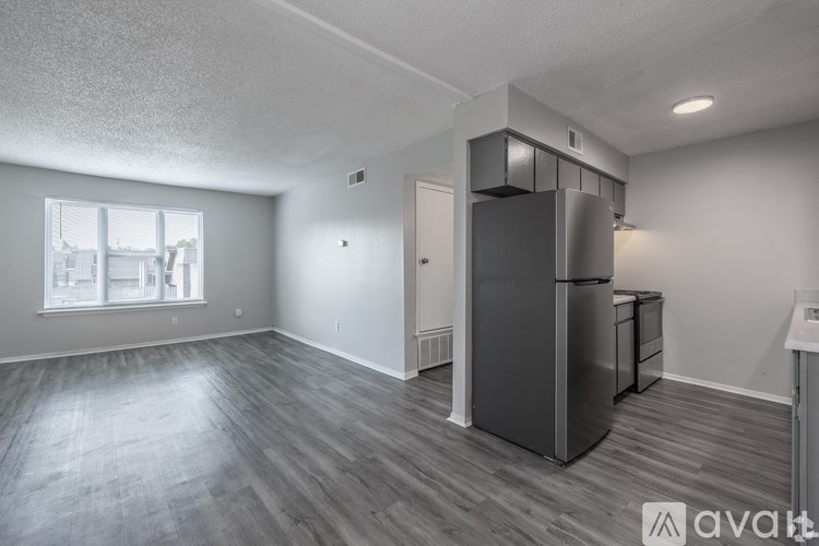 A spacious kitchen area with a refrigerator, sink, and a window.