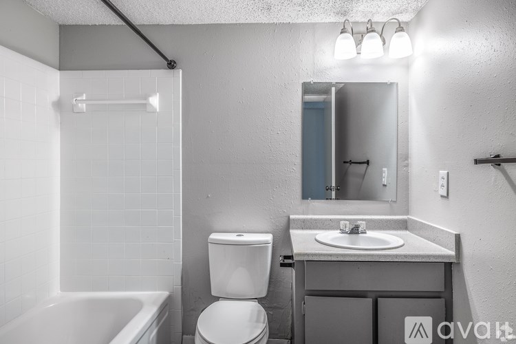 A bathroom with a toilet, sink, and bathtub.