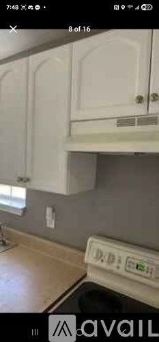 A white cabinet is mounted on a wall.