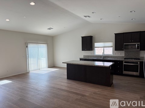 A spacious kitchen with dark wood cabinets and a granite countertop.