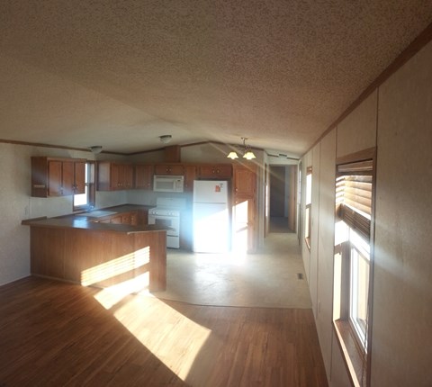 A kitchen with wooden cabinets and a microwave.