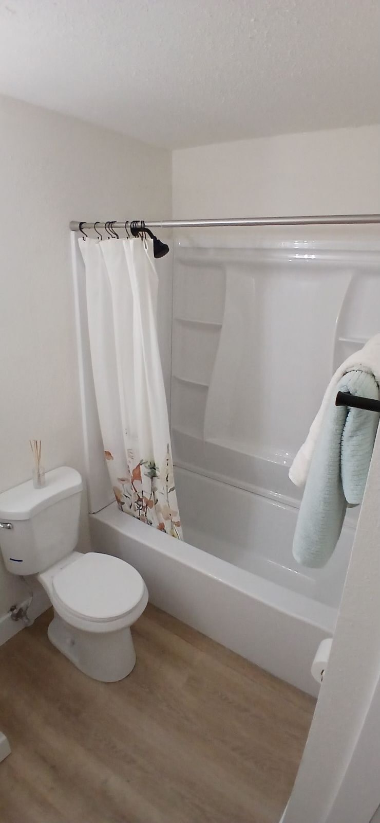 A white toilet sits next to a bathtub in a bathroom.