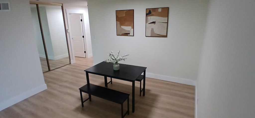 A black table with a vase on it and two black stools.