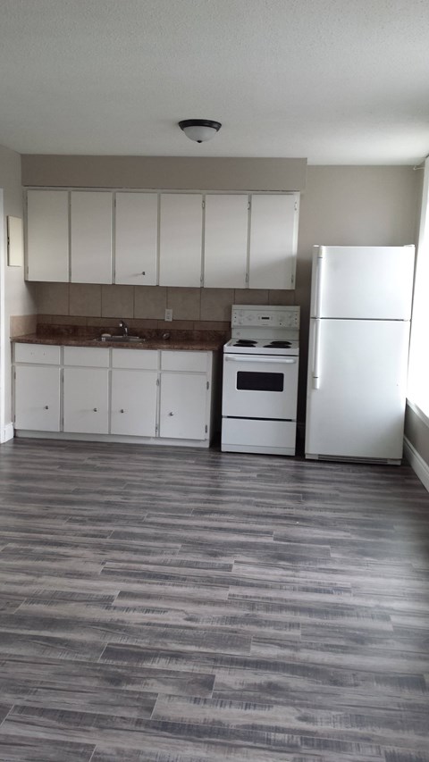 A kitchen with white appliances and cabinets.