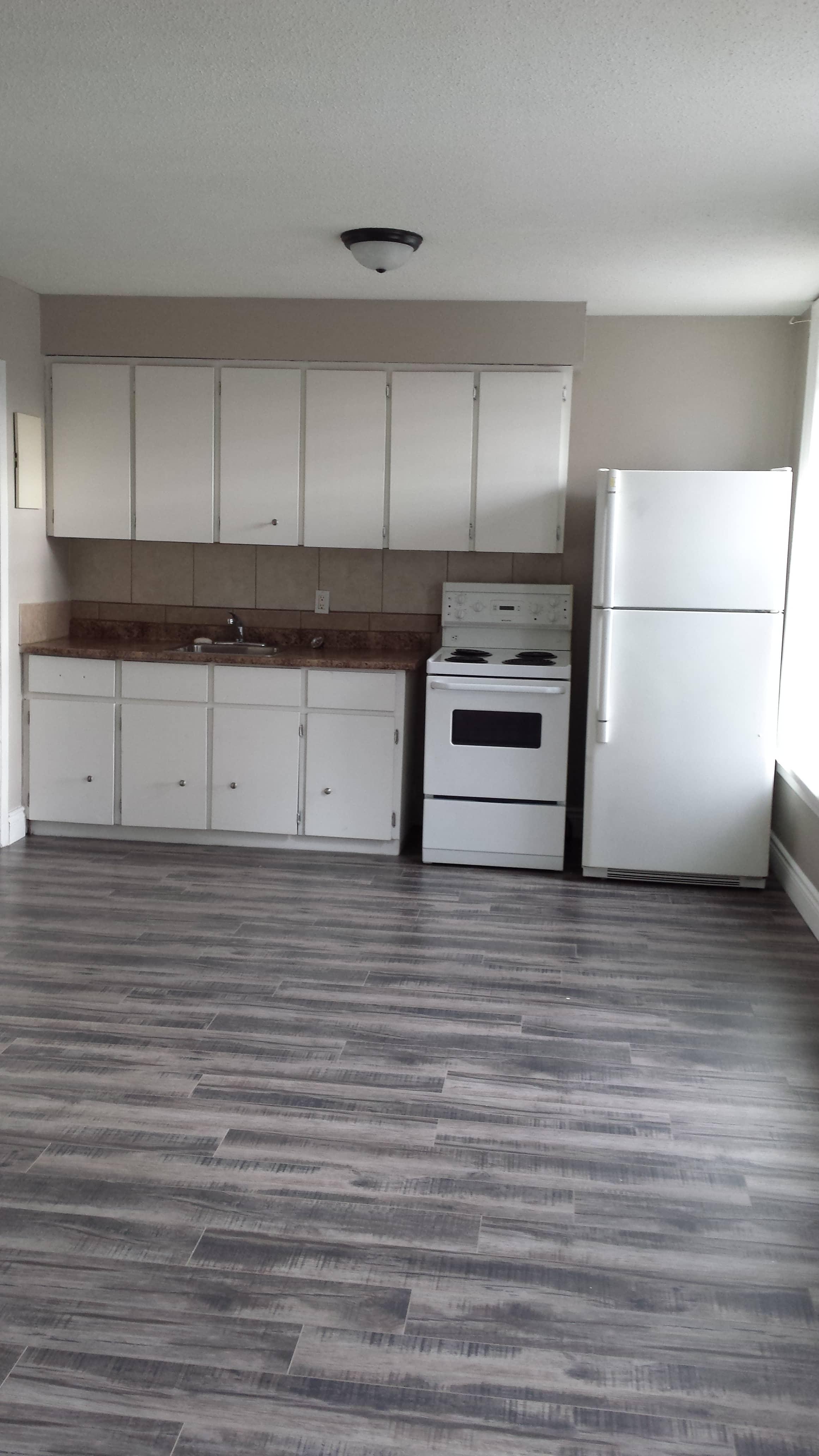 A kitchen with white appliances and cabinets.