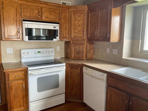 A kitchen with wooden cabinets and white appliances.