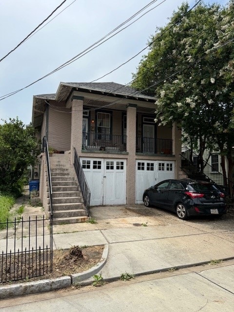 A black car is parked in front of a white garage door.