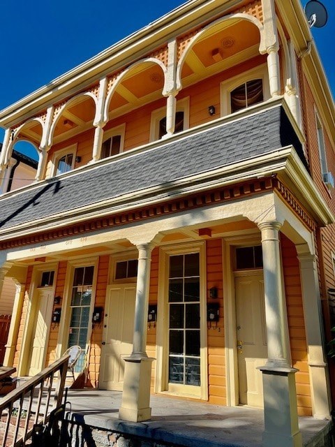 A yellow building with a black roof and white columns.