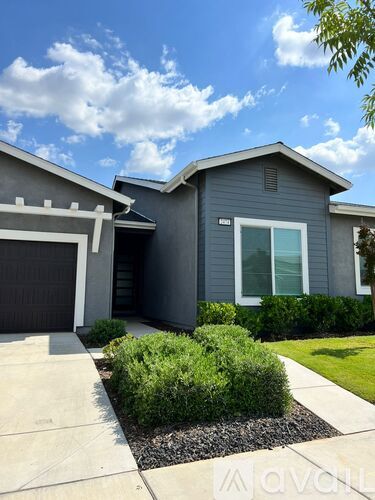 A modern house with a grey exterior and a white garage door.