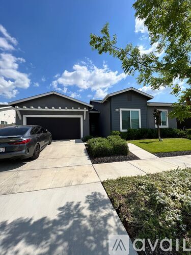 A modern house with a grey car parked in front.