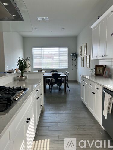 A kitchen with white cabinets and a black stove top.