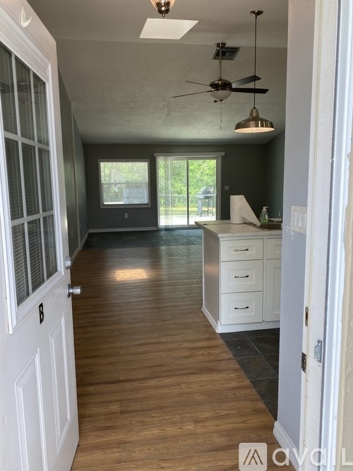 A room with a ceiling fan and a door.