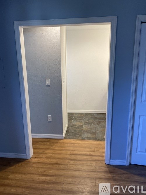 A room with a white door and a wooden floor.