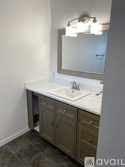 A bathroom vanity with a sink and a mirror.