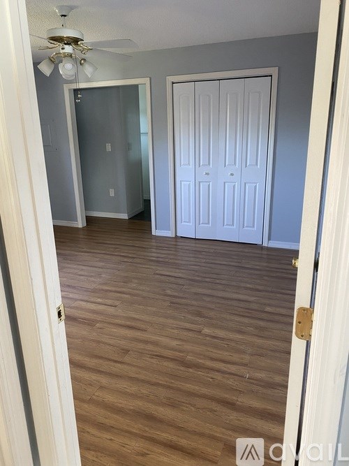A room with a white door and a ceiling fan.