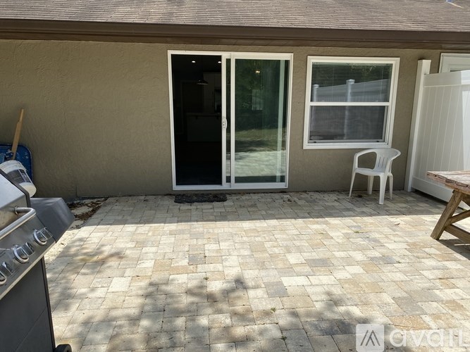 A patio with a table and chairs and a grill.