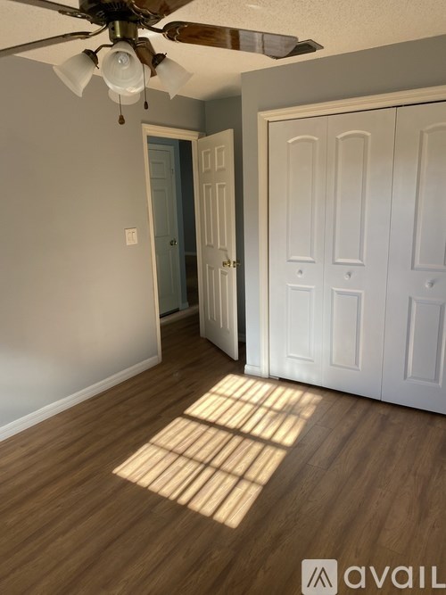 A room with a ceiling fan and a door.