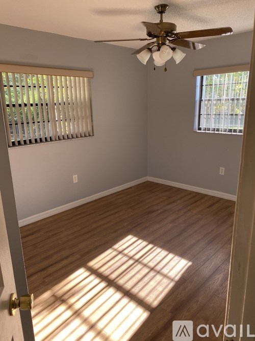 A room with wooden floors and a ceiling fan.