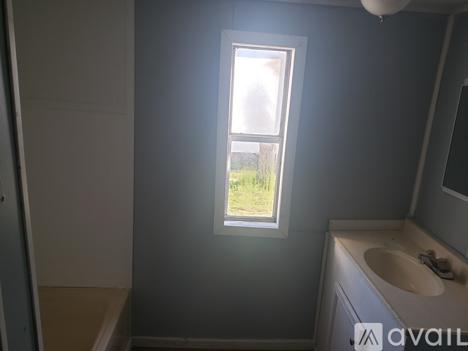 A bathroom with a window and a sink.