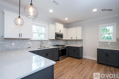 A kitchen with white countertops and black cabinets.