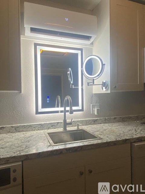 A modern kitchen with a sink and a mirror.