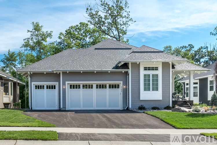 A two-car garage with a white door is attached to a house.