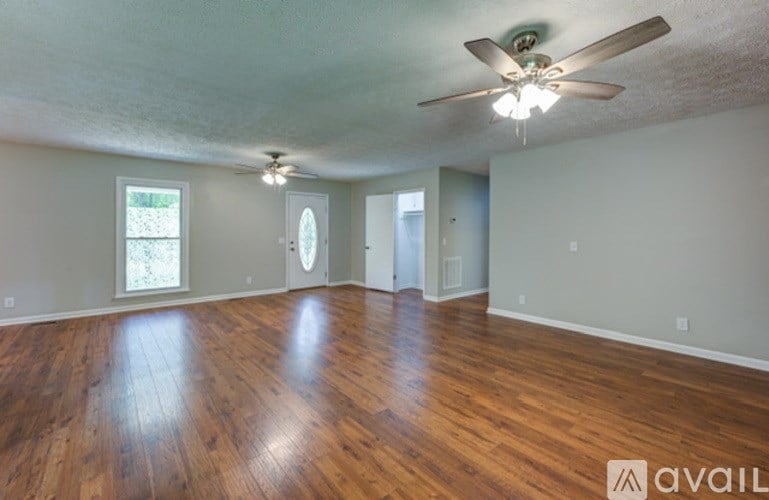 A room with wooden floors and a ceiling fan.