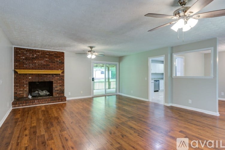 A room with a fireplace and wood flooring.