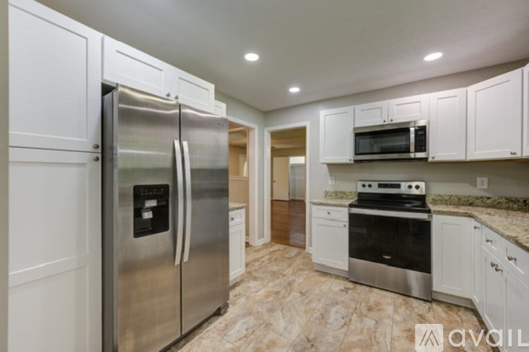 A kitchen with a stainless steel refrigerator, microwave, and oven.