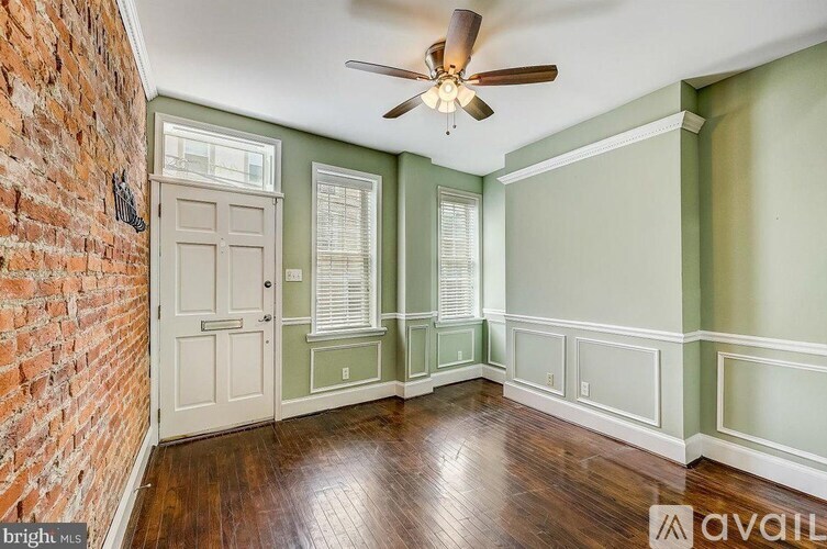 A room with a brick wall and a ceiling fan.