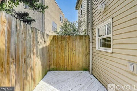 A wooden fence separates a backyard from a house.