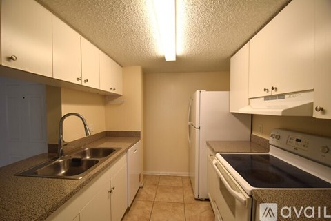 A kitchen with white cabinets and appliances.
