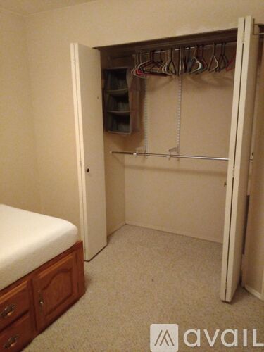 A bedroom with a bed, wardrobe and a carpet.