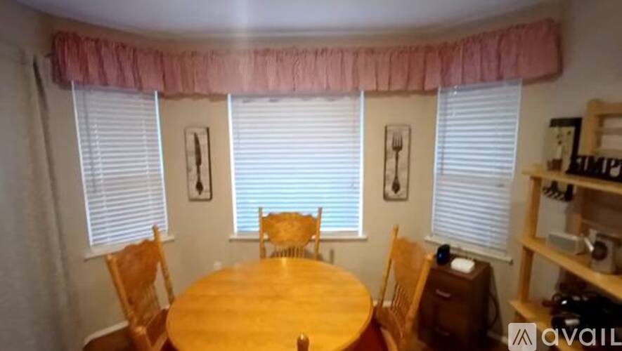 A dining room with a wooden table and chairs.