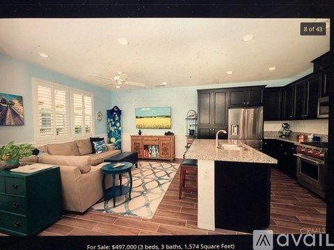 A kitchen with a black countertop and a sink is for sale.