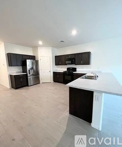 A kitchen with black cabinets and a white countertop.
