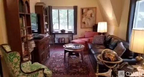 A living room with a red couch and a green armchair.