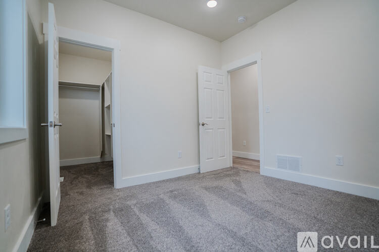 A room with a carpeted floor and a door on the left side.