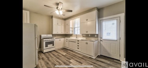 A kitchen with white appliances and cabinets is available for rent.