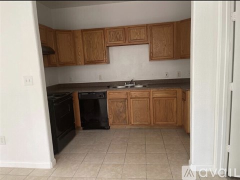 A kitchen with wooden cabinets and black appliances.