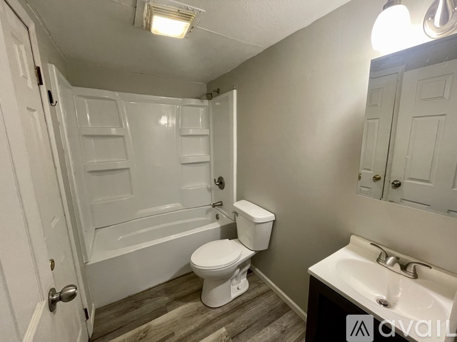 A white bathroom with a toilet, sink, and bathtub.